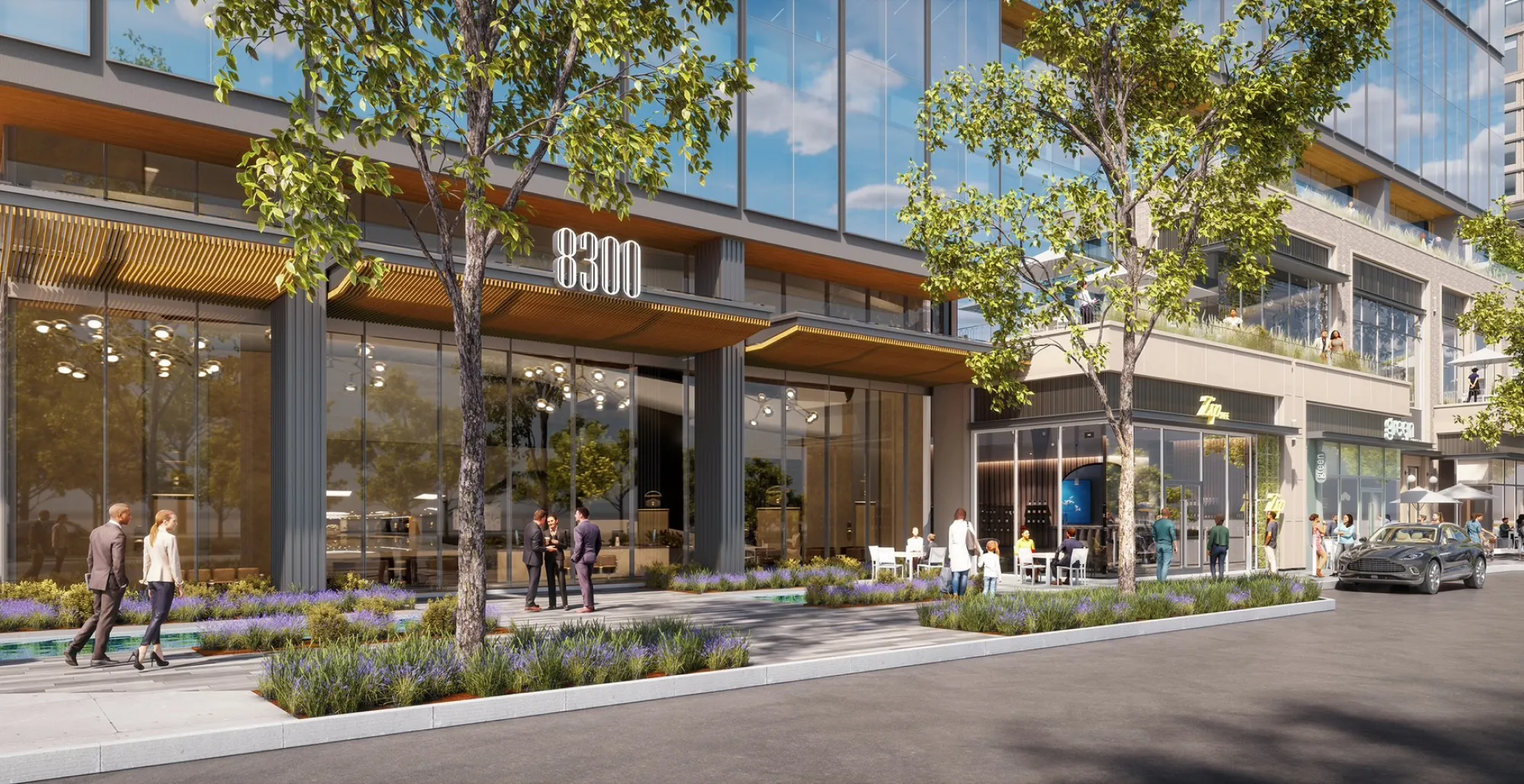 Street-level view of contemporary office and retail complex featuring greenery and open-air patios