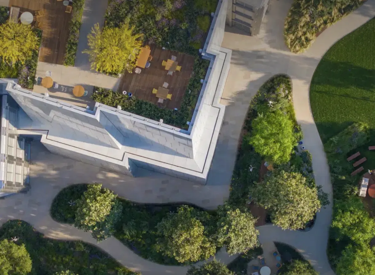Overhead view of rooftop garden with wooden seating decks and surrounding walking paths and greenery