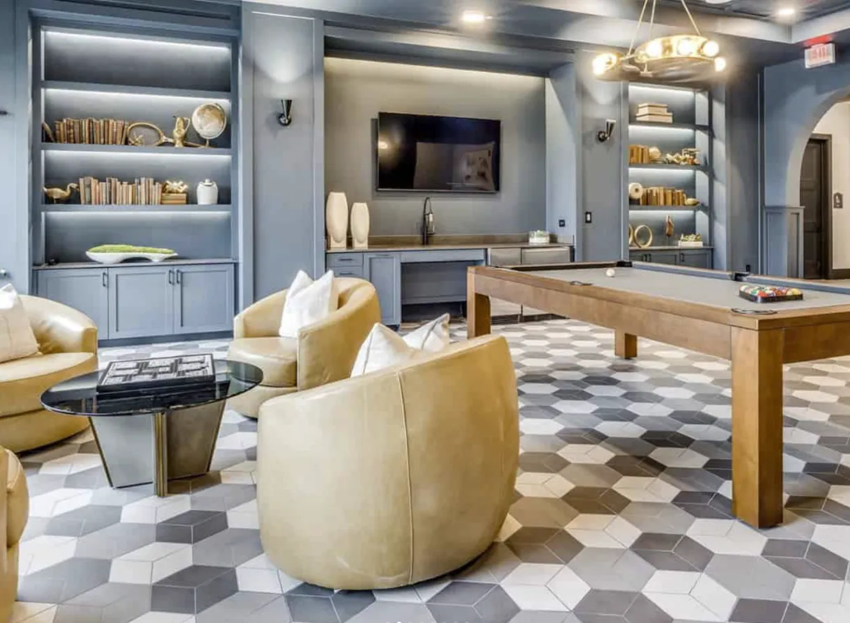 Elegant rec room design with sleek decor, soft lighting, and built-in blue cabinetry surrounding amenities